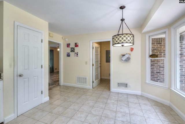 unfurnished dining area featuring light tile patterned floors and baseboards