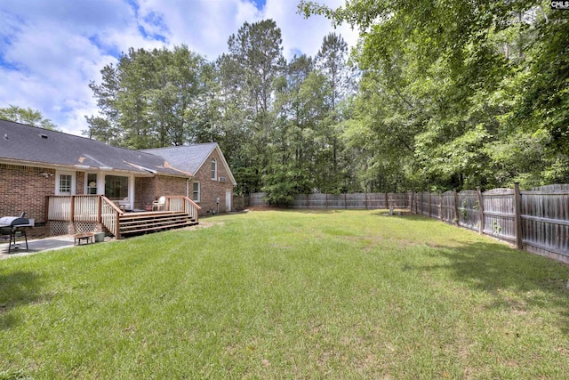 view of yard with a wooden deck and a patio