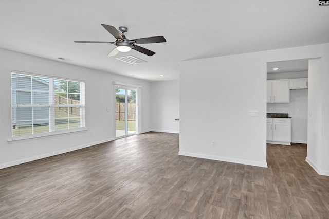 unfurnished living room featuring a ceiling fan, wood finished floors, baseboards, and recessed lighting