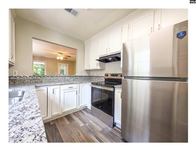 kitchen featuring stainless steel appliances, under cabinet range hood, white cabinetry, and wood finished floors
