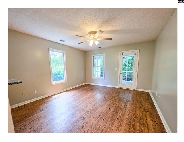 unfurnished room with wood finished floors, a ceiling fan, baseboards, and a textured ceiling