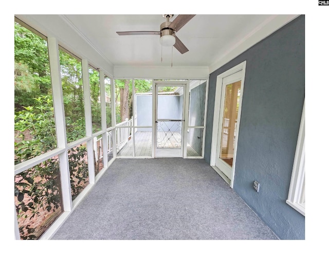 unfurnished sunroom with ceiling fan and plenty of natural light