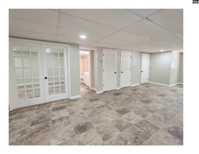 spare room with french doors, a paneled ceiling, baseboards, and recessed lighting