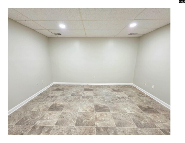 unfurnished room featuring a drop ceiling, recessed lighting, and baseboards