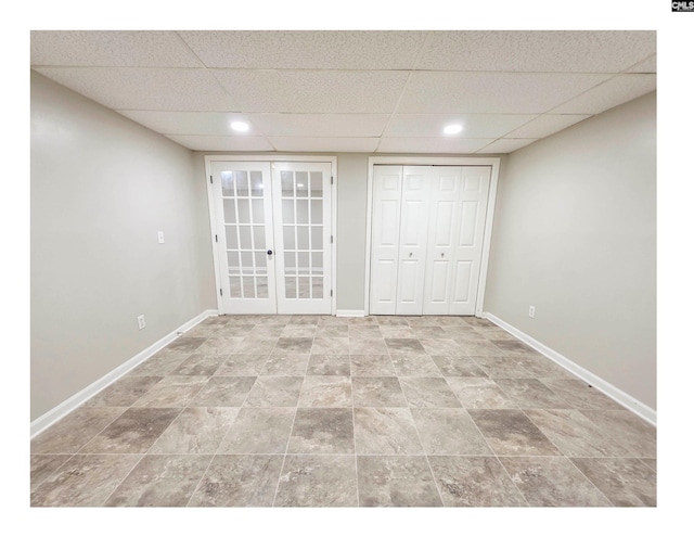 unfurnished bedroom with a drop ceiling, baseboards, french doors, recessed lighting, and a closet