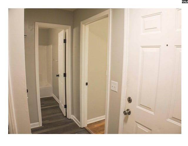 hallway with dark wood-style floors and baseboards