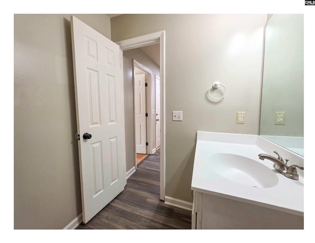 bathroom with wood finished floors, baseboards, and vanity