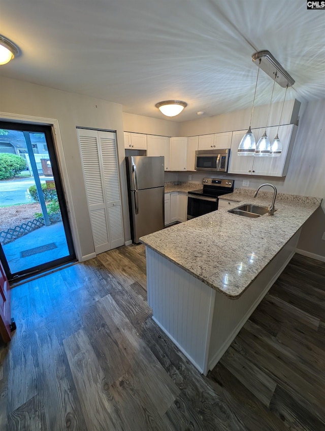 kitchen featuring stainless steel appliances, a sink, a peninsula, light stone countertops, and baseboards