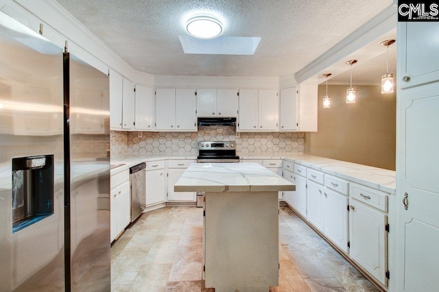 7905 Castleton Ln, Columbia, SC 29223 - kitchen featuring appliances with stainless steel finishes, under cabinet range hood, decorative backsplash, a kitchen island, and a skylight