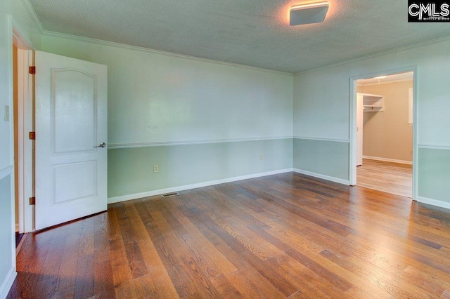 7905 Castleton Ln, Columbia, SC 29223 - spare room featuring wood finished floors, ornamental molding, a textured ceiling, and baseboards