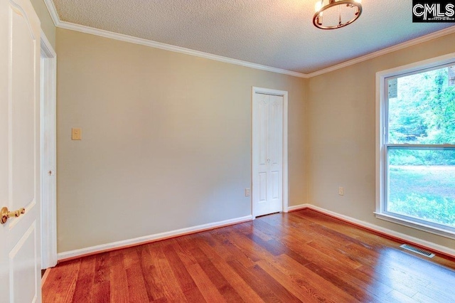 7905 Castleton Ln, Columbia, SC 29223 - spare room featuring wood finished floors, plenty of natural light, baseboards, a textured ceiling, and ornamental molding