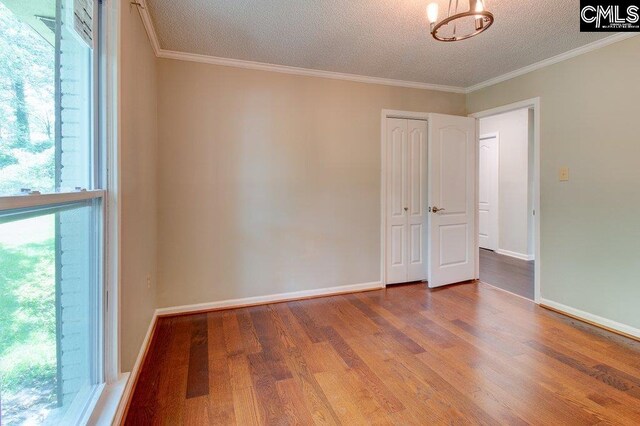 7905 Castleton Ln, Columbia, SC 29223 - spare room featuring a textured ceiling, wood finished floors, plenty of natural light, baseboards, and crown molding
