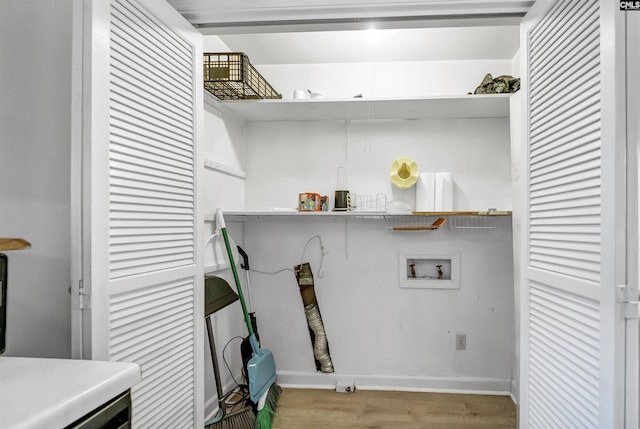 washroom with hookup for a washing machine, wood finished floors, and baseboards
