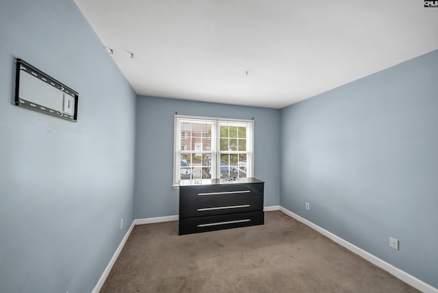 carpeted spare room with baseboards