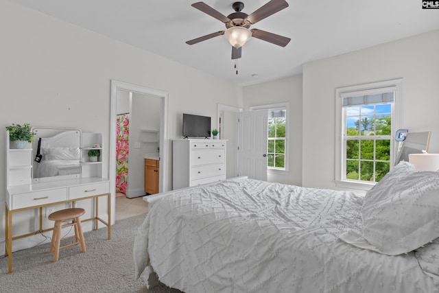 bedroom featuring light carpet, light tile patterned floors, and a ceiling fan