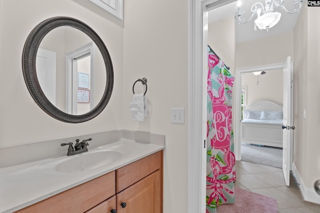 bathroom with tile patterned floors, a chandelier, and vanity