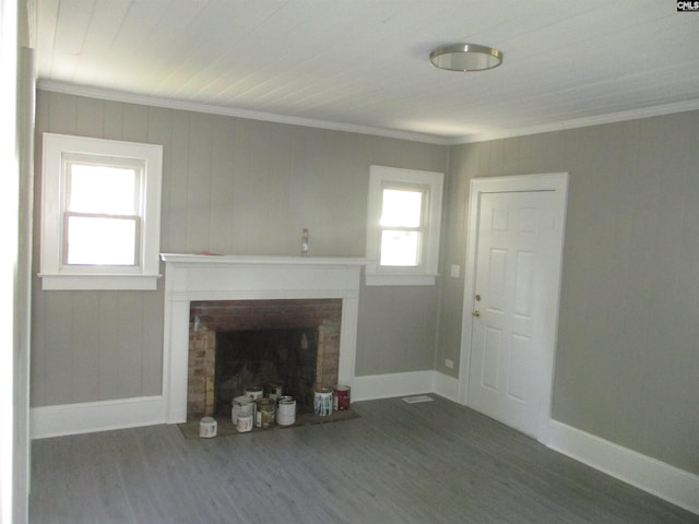 unfurnished living room with a brick fireplace, baseboards, wood finished floors, and crown molding