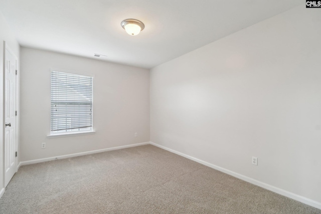 spare room featuring baseboards and carpet