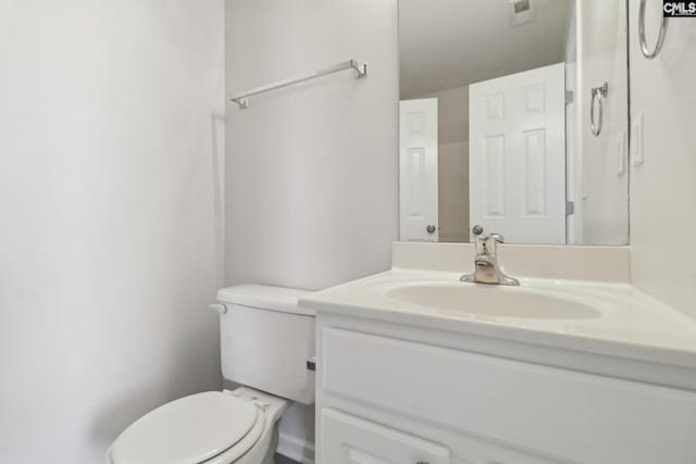 half bathroom with vanity and toilet