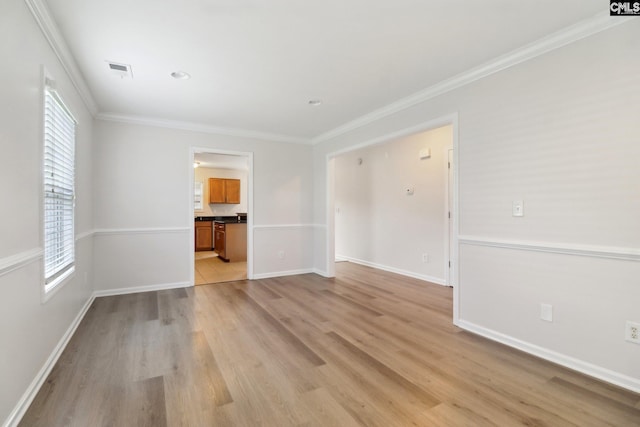 unfurnished living room featuring light wood-style flooring, plenty of natural light, crown molding, and baseboards