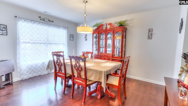 dining area featuring dark wood-style flooring and baseboards