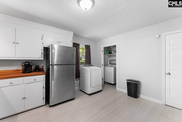 4306 Windemere Ave, Columbia, SC 29203 - kitchen featuring washer / dryer, freestanding refrigerator, white cabinetry, and a textured ceiling
