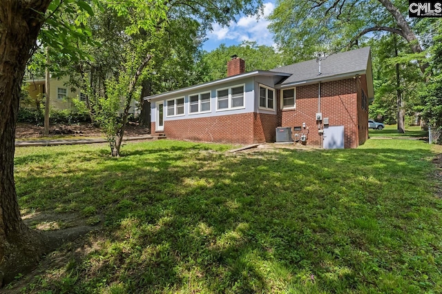4306 Windemere Ave, Columbia, SC 29203 - back of property featuring brick siding, a chimney, a lawn, and central air condition unit