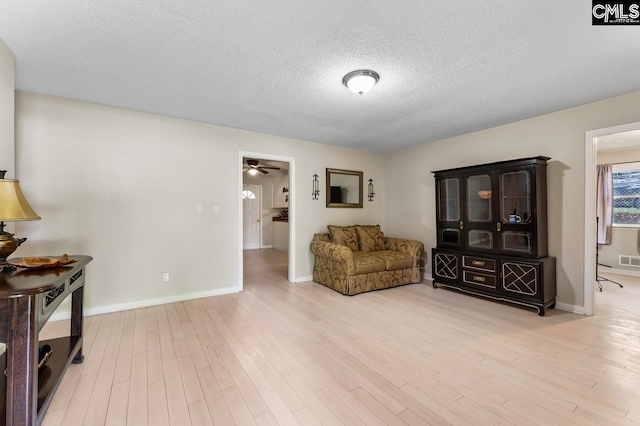 4306 Windemere Ave, Columbia, SC 29203 - living area featuring a textured ceiling, wood finished floors, baseboards, and ceiling fan