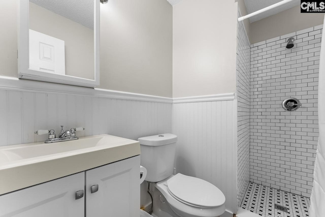 4306 Windemere Ave, Columbia, SC 29203 - bathroom featuring a wainscoted wall, a shower stall, toilet, vanity, and a textured ceiling