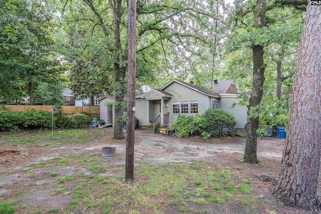 view of front of home with fence, a storage shed, and an outdoor structure
