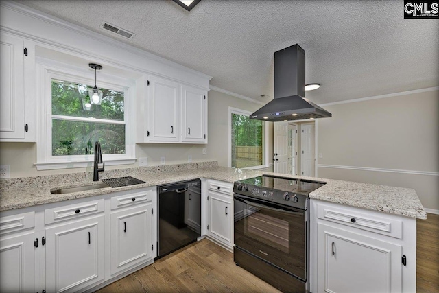 1045 Manchester Cir, Sumter, SC 29154 - kitchen featuring island exhaust hood, black appliances, a sink, a peninsula, and white cabinetry