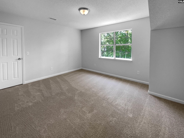 spare room featuring carpet flooring, a textured ceiling, and baseboards