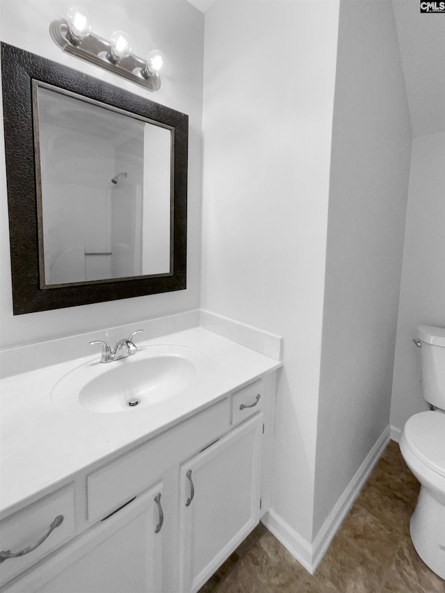 bathroom with toilet, vanity, and baseboards