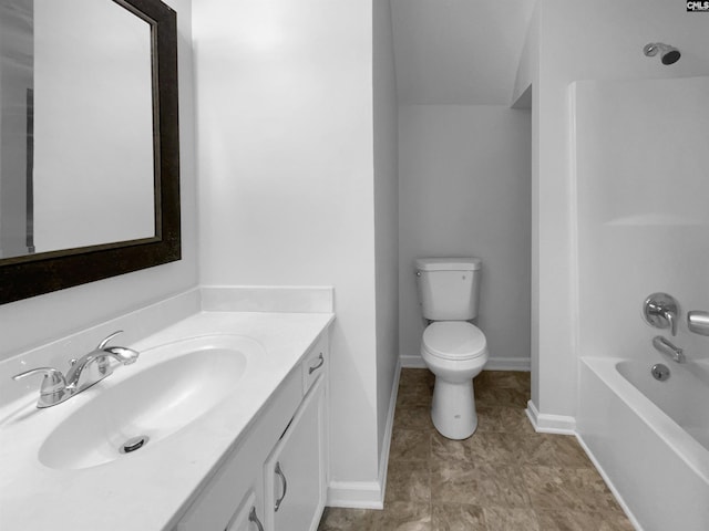 bathroom featuring toilet, vanity, baseboards, and shower / washtub combination