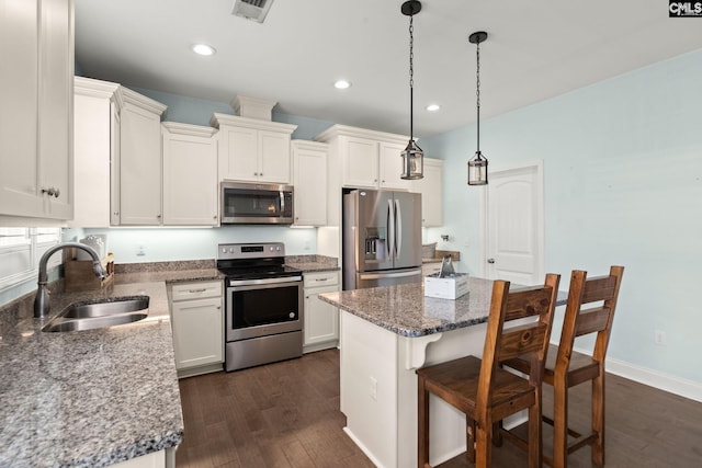 1307 Dusty Rd, Cope, SC 29038 - kitchen with appliances with stainless steel finishes, a sink, dark wood-style floors, a kitchen bar, and a kitchen island