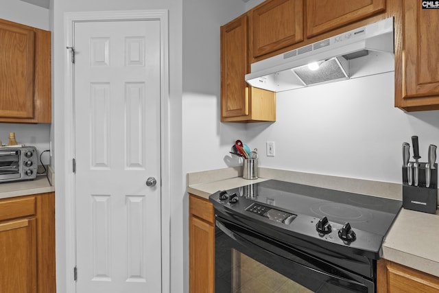 311 Coventry Lake Dr, Lexington, SC 29072 - kitchen featuring under cabinet range hood, black range with electric cooktop, brown cabinets, and light countertops