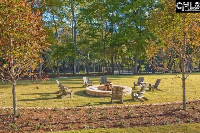 view of community featuring an outdoor fire pit and a lawn