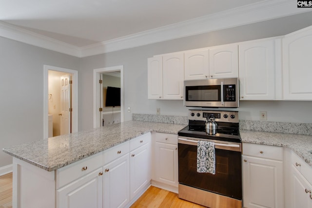 1029 Maxcy St, Columbia, SC 29201 - kitchen with appliances with stainless steel finishes, a peninsula, light wood-style floors, white cabinets, and crown molding