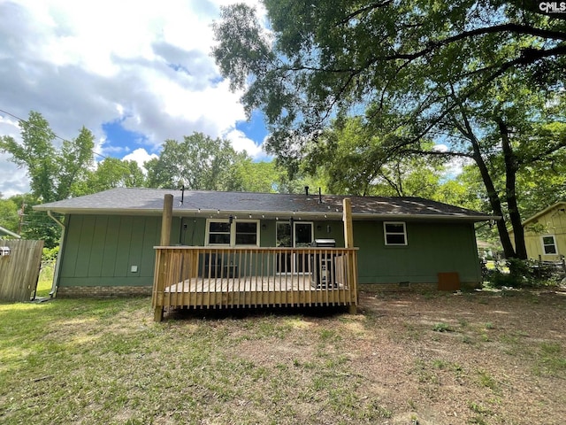 back of house with crawl space, a deck, and a lawn