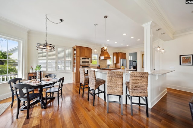 3011 River Vista Way, Mount Pleasant, SC 29466 - kitchen featuring brown cabinets, plenty of natural light, dark wood-style flooring, ornamental molding, and a kitchen breakfast bar