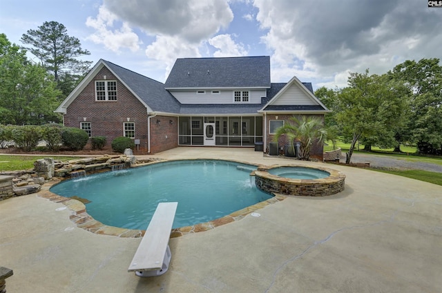 view of swimming pool with a sunroom, a patio area, a diving board, and a pool with connected hot tub