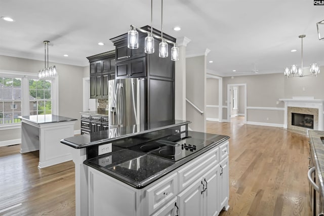 kitchen featuring a center island, stainless steel fridge with ice dispenser, crown molding, light wood-style floors, and recessed lighting