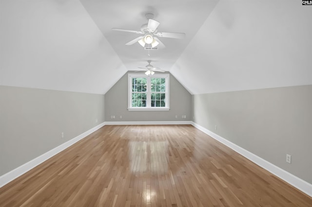 bonus room featuring light wood-style flooring, a ceiling fan, lofted ceiling, and baseboards