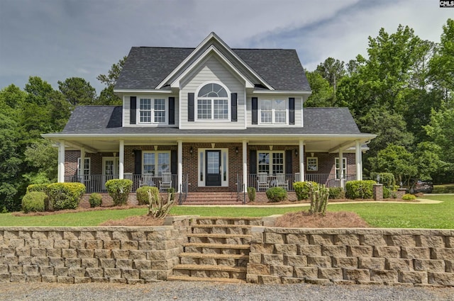 colonial home featuring covered porch, brick siding, roof with shingles, and a front lawn