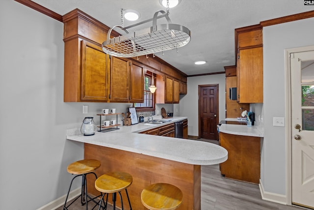 3040 Barnes Springs Rd, Columbia, SC 29204 - kitchen featuring stainless steel dishwasher, light countertops, baseboards, brown cabinets, and a sink