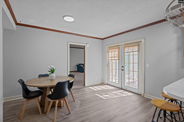 3040 Barnes Springs Rd, Columbia, SC 29204 - dining space featuring french doors, a textured ceiling, baseboards, crown molding, and wood finished floors