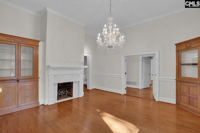 2203 Lincoln St, Columbia, SC 29201 - unfurnished living room featuring wood finished floors, a chandelier, crown molding, a high end fireplace, and baseboards