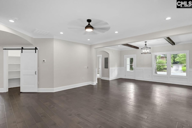 1409 Woodrow St, Columbia, SC 29205 - unfurnished living room with a barn door, ceiling fan, dark wood-style floors, a wainscoted wall, and arched walkways