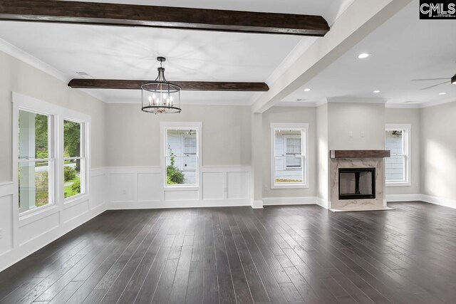 1409 Woodrow St, Columbia, SC 29205 - unfurnished living room featuring healthy amount of natural light, beam ceiling, dark wood-type flooring, a chandelier, and wainscoting