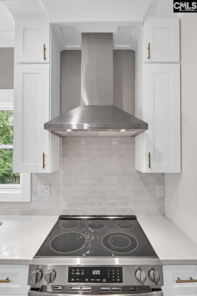 1409 Woodrow St, Columbia, SC 29205 - kitchen with wall chimney range hood, stainless steel electric range, white cabinets, and decorative backsplash
